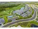 Aerial view of condo community featuring pool, golf course, pond, and winding roads at 12470 Wellen Golf St # 107, Venice, FL 34293