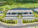 Beautiful aerial view of condo building overlooking golf course, pond and garages with palm trees at 12470 Wellen Golf St # 107, Venice, FL 34293