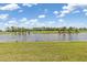 Gorgeous backyard view of lush greenery and a serene lake at 12470 Wellen Golf St # 107, Venice, FL 34293