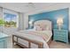 Cozy bedroom with a stylish accent wall, comfortable bed, and ample natural light at 12470 Wellen Golf St # 107, Venice, FL 34293