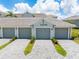 A well-maintained garage with a gray door and paved driveway is set beneath a clean modern unit at 12470 at 12470 Wellen Golf St # 107, Venice, FL 34293