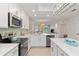 Bright, modern kitchen with white cabinetry, stainless steel appliances, and a stylish tile backsplash at 12470 Wellen Golf St # 107, Venice, FL 34293