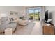 Comfortable living room with stylish decor, a sectional sofa, and a view of the serene outdoor landscape at 12470 Wellen Golf St # 107, Venice, FL 34293