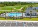 A serene community pool is surrounded by a gated fence, shaded by palms, and conveniently placed by parking at 12470 Wellen Golf St # 107, Venice, FL 34293