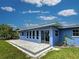 Rear exterior view showcasing backyard patio and freshly painted blue exterior at 1295 S Maryknoll Rd, Englewood, FL 34223