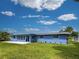 A well-maintained, blue home has a spacious, grassy backyard perfect for outdoor activities and relaxation at 1295 S Maryknoll Rd, Englewood, FL 34223