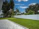 Landscaped backyard featuring a well-maintained lawn, white fence, and a patio at 1295 S Maryknoll Rd, Englewood, FL 34223