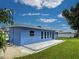 Back of house featuring a patio, well-maintained lawn, and a white fence at 1295 S Maryknoll Rd, Englewood, FL 34223