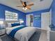 Bedroom with blue walls, ceiling fan, gray tile flooring, closet and furnished with a bed and night stand at 1295 S Maryknoll Rd, Englewood, FL 34223