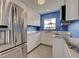 Modern kitchen featuring stainless steel refrigerator and white cabinets for ample storage and style at 1295 S Maryknoll Rd, Englewood, FL 34223