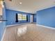 Spacious living room with tile floors, large window and a view of the front door at 1295 S Maryknoll Rd, Englewood, FL 34223