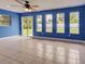 Bright living room features tile flooring, a ceiling fan, and large windows offering backyard views at 1295 S Maryknoll Rd, Englewood, FL 34223