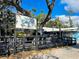 Inviting restaurant entrance with outdoor seating, lush trees and the Blue Pineapple Bistro sign at 1295 S Maryknoll Rd, Englewood, FL 34223