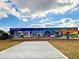 Colorful Greetings from Englewood mural on a sunny day with blue skies and fluffy clouds at 1295 S Maryknoll Rd, Englewood, FL 34223