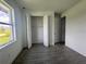 Bright bedroom with wood-look tile flooring, bi-fold closet, and white walls at 14149 Whittier Ln, Port Charlotte, FL 33981