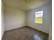 Light-filled bedroom with wood-look tile flooring and white walls at 14149 Whittier Ln, Port Charlotte, FL 33981