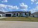 Charming one-story home with well-manicured front lawn and attached two car garage, plus some decorative palms at 14149 Whittier Ln, Port Charlotte, FL 33981