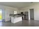 Bright kitchen featuring white cabinetry, stainless steel appliances, an island with quartz countertops, and patterned backsplash at 14149 Whittier Ln, Port Charlotte, FL 33981