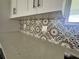 Close-up of quartz countertops, patterned backsplash, and white cabinetry with dark hardware at 14149 Whittier Ln, Port Charlotte, FL 33981