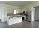 Bright kitchen featuring white cabinetry, stainless steel appliances, an island with quartz countertops, and patterned backsplash at 14149 Whittier Ln, Port Charlotte, FL 33981