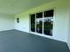 Outdoor patio featuring sliding glass doors with dark trim and a concrete floor at 14149 Whittier Ln, Port Charlotte, FL 33981