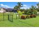 Fenced backyard with lovely landscaping, offering a serene view of the screened-in patio and trees at 1415 Bayshore Dr, Englewood, FL 34223
