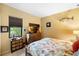 Well-lit bedroom featuring beige walls, a comfortable bed with a colorful ocean-themed comforter, and wooden furniture at 1415 Bayshore Dr, Englewood, FL 34223