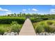 Inviting wooden dock surrounded by lush greenery leading to tranquil waterfront at 1415 Bayshore Dr, Englewood, FL 34223