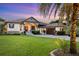 Well-manicured home exterior with lush landscaping, large lawn and a paved driveway at 1415 Bayshore Dr, Englewood, FL 34223