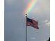 Flagpole with American flag featuring a beautiful rainbow in the background at 1415 Bayshore Dr, Englewood, FL 34223