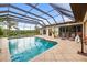 Relaxing screened-in pool area with views of the lake and cozy seating at 1415 Bayshore Dr, Englewood, FL 34223