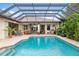 Beautifully designed backyard with a screened pool and outdoor seating area at 1415 Bayshore Dr, Englewood, FL 34223