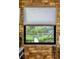 Brick wall with a window showcasing a beautiful view of the outdoor landscape at 1415 Bayshore Dr, Englewood, FL 34223