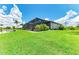 Beautiful backyard featuring a screened-in lanai, lush lawn, and mature landscaping, offering a private outdoor oasis at 15498 Seafoam Cir, Port Charlotte, FL 33981