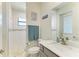 Bright bathroom features a large mirror, white marble countertop, decorative signs, and a walk-in shower at 15498 Seafoam Cir, Port Charlotte, FL 33981