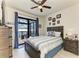 Bedroom with a ceiling fan, a bed, and sliding glass doors that lead to the outside patio and a waterfront view at 15498 Seafoam Cir, Port Charlotte, FL 33981