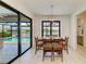 Inviting dining room with views of the pool and lake, complemented by a modern chandelier and tile flooring at 15498 Seafoam Cir, Port Charlotte, FL 33981