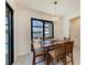 Dining space featuring views of the pool and canal, complemented by a contemporary chandelier and tile floors at 15498 Seafoam Cir, Port Charlotte, FL 33981