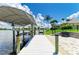 Waterfront home featuring a private boat dock with canopy, lift, and paver stone patio overlooking the waterway at 15498 Seafoam Cir, Port Charlotte, FL 33981