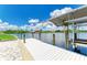 Home with private dock featuring canopy-covered boat lift, set along a serene waterway under a bright blue sky at 15498 Seafoam Cir, Port Charlotte, FL 33981