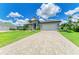 Wide, paved driveway leading to a well-maintained, single-story home with a two-car garage at 15498 Seafoam Cir, Port Charlotte, FL 33981