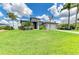 Beautiful single-story home with a manicured lawn, tropical landscaping, and a two-car garage at 15498 Seafoam Cir, Port Charlotte, FL 33981