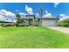 Beautiful single-story home with a manicured lawn, tropical landscaping, and a two-car garage at 15498 Seafoam Cir, Port Charlotte, FL 33981