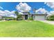 Beautiful single-story home with a manicured lawn, tropical landscaping, and a two-car garage at 15498 Seafoam Cir, Port Charlotte, FL 33981