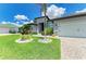 Well-manicured front yard with lush landscaping and a paved walkway to the modern home's entrance at 15498 Seafoam Cir, Port Charlotte, FL 33981