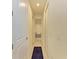 Hallway with tiled floors that leads to a bathroom and has white walls with matching white doors at 15498 Seafoam Cir, Port Charlotte, FL 33981