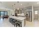 Open kitchen and dining area with a large island featuring seating, stainless steel appliances, and sleek gray cabinets at 15498 Seafoam Cir, Port Charlotte, FL 33981