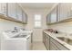 Functional laundry room featuring modern appliances, ample cabinet space, and granite countertops at 15498 Seafoam Cir, Port Charlotte, FL 33981