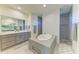 Luxurious main bathroom featuring a standalone tub, walk-in shower, double vanity, and modern fixtures at 15498 Seafoam Cir, Port Charlotte, FL 33981