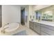 Elegant bathroom featuring a standalone tub, walk-in shower, double vanity, and modern fixtures at 15498 Seafoam Cir, Port Charlotte, FL 33981
